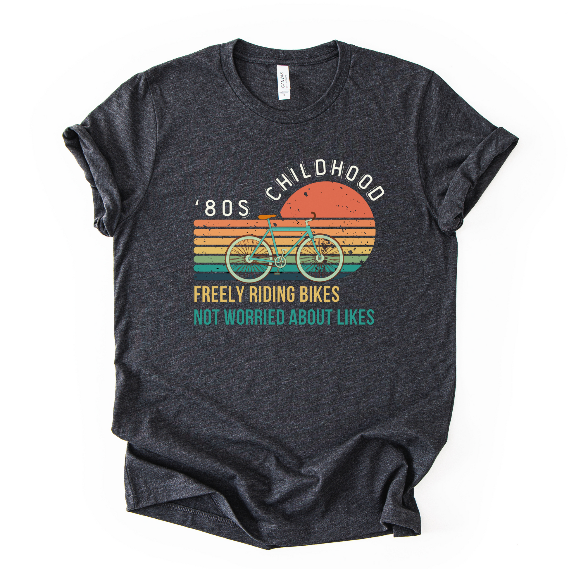 Dark gray t-shirt with a graphic of a bicycle and text on a white background. Created for those who survived 80s childhood.