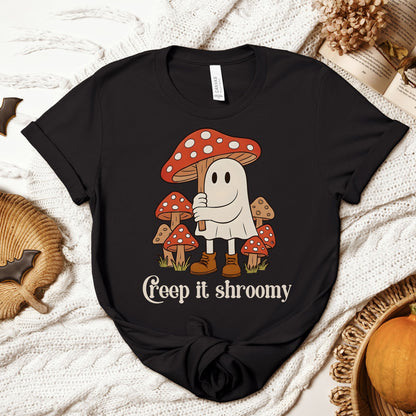 Black t-shirt with a ghost and mushroom design on a textured surface.