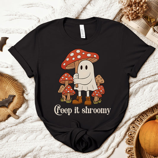 Black t-shirt with a ghost and mushroom design on a textured surface.