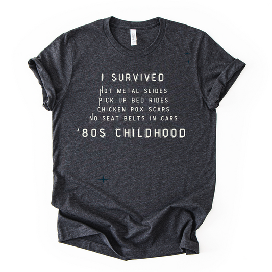 Dark gray t-shirt with white text on a white background that says I survived 80s childhood.