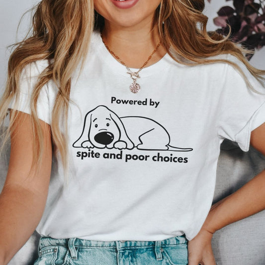 Beige t-shirt with a dog graphic and text 'Powered by spite and poor choices' on a beige background.