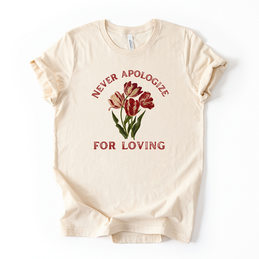 Beige t-shirt with red tulips and text 'Never apologize for loving' on a white background. Love is love.