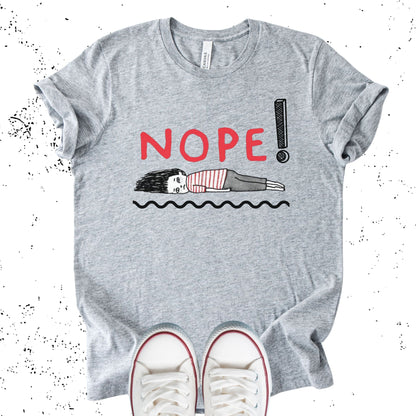 Unisex Zeke Squad T-shirt with the phrase “Nope” and a graphic of a woman lying flat, representing burnout and exhaustion.