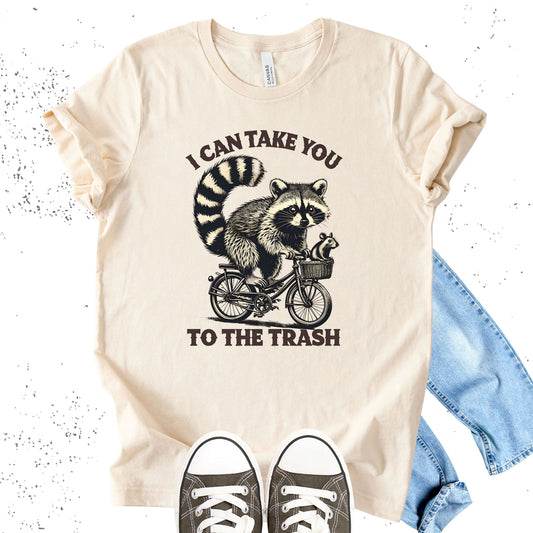 Unisex Zeke Squad T-shirt with a vintage-style graphic of a raccoon riding a bike and the phrase “I can take you to the trash.