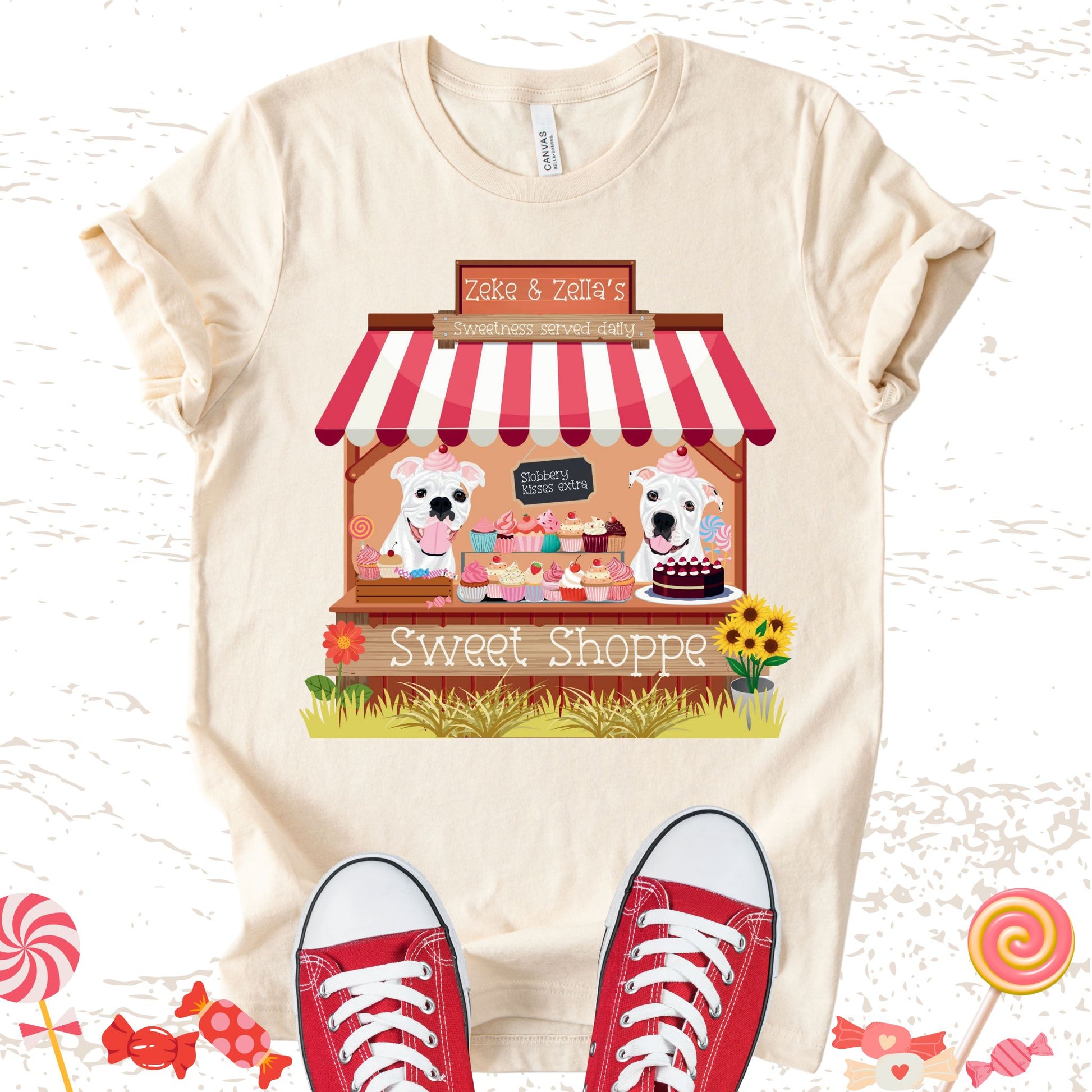 Unisex Zeke Squad T-shirt with a graphic of Zeke and Zella behind a candy shop counter and a sign that says “Slobbery kisses extra.”